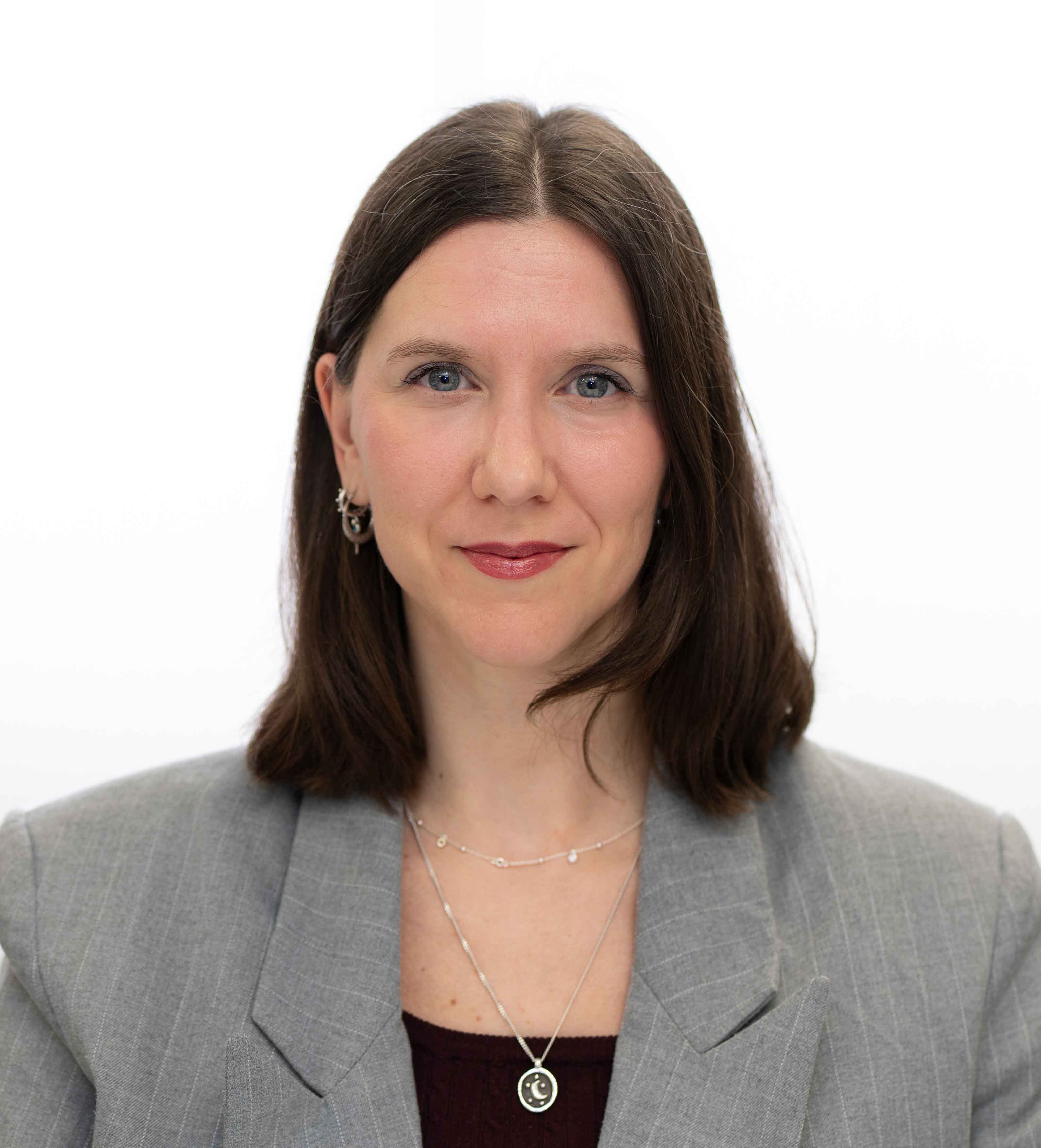 Corporate headshot of a woman in a grey blazer