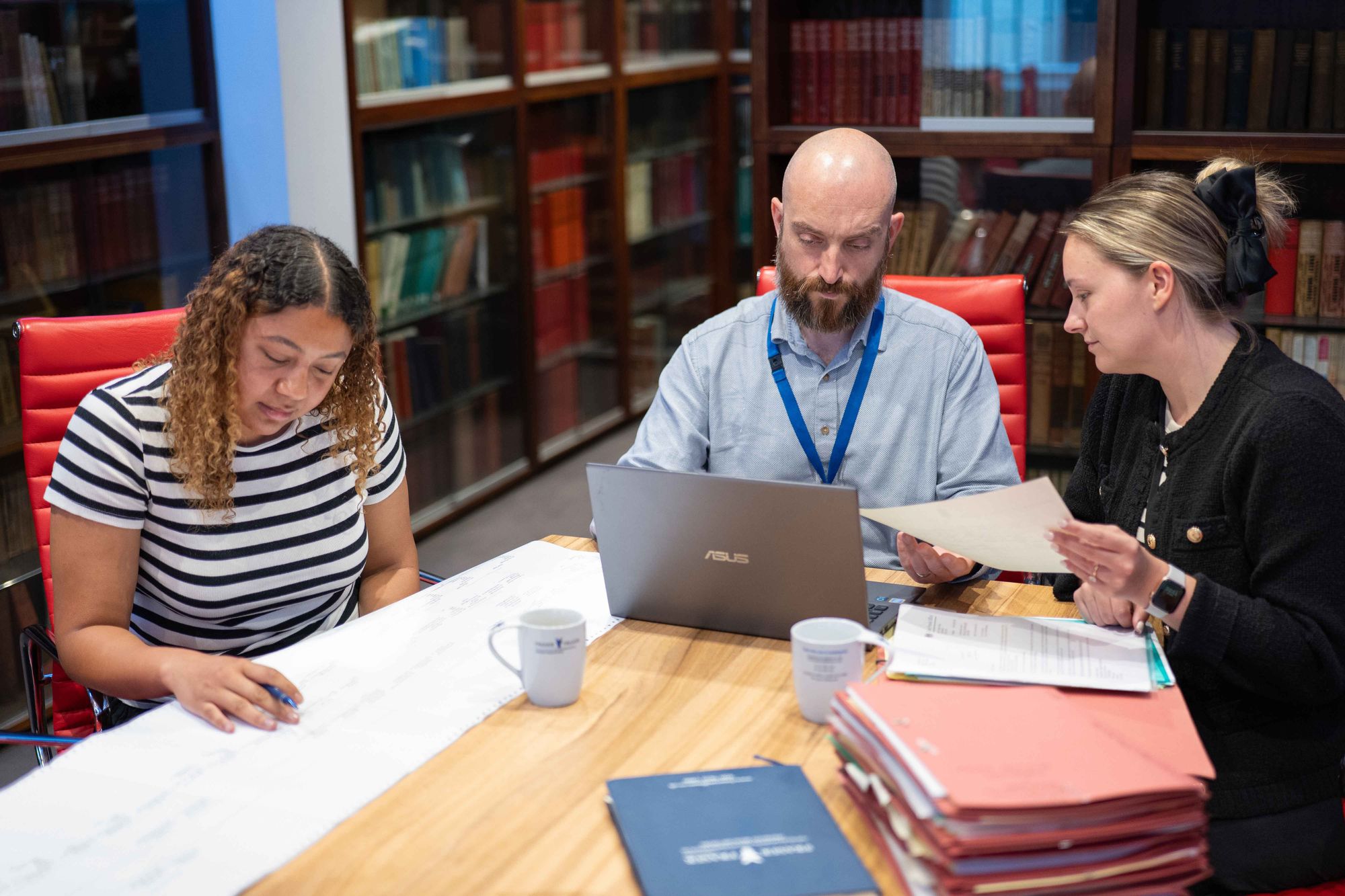 Team reviewing genealogy records in the library