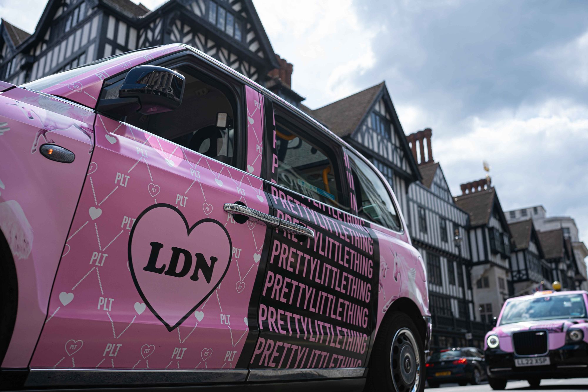 PrettyLittleThing branded pink taxi parked near Tower Bridge