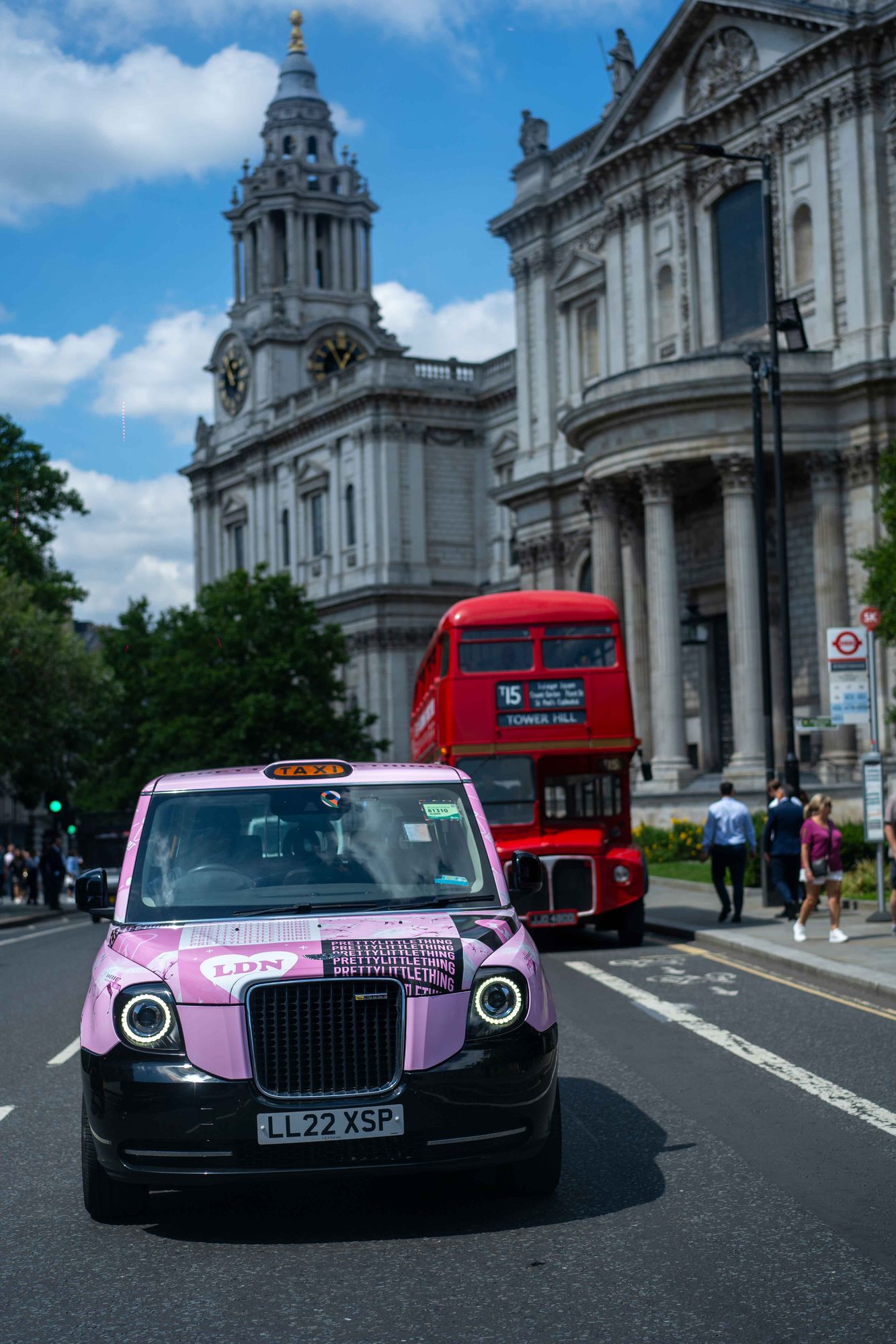 PrettyLittleThing branded pink taxi outside a Tudor building in London